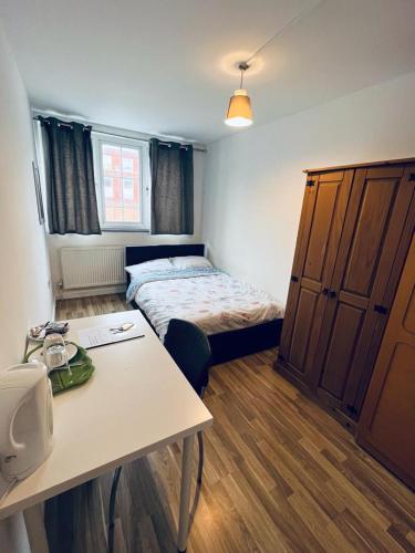 a small room with a bed and a table at Jey's Flat in Liverpool