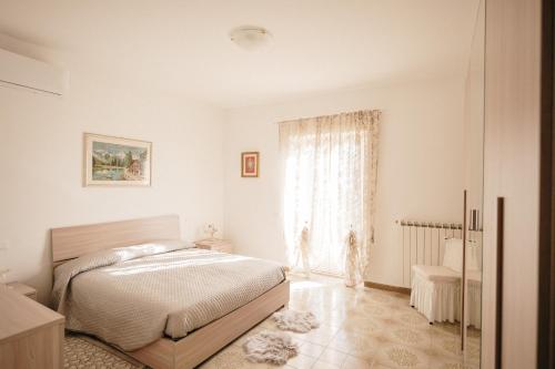a white bedroom with a bed and a window at (Incanto sul Lago Turano) la vista panoramica più bella in Ascrea