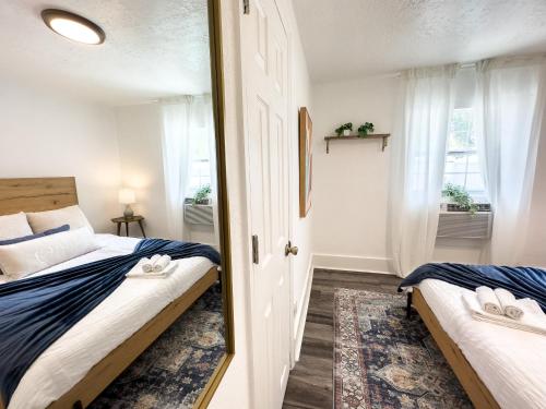 1 dormitorio con 2 camas y espejo en 2b1b Stylish Little House W Shared Pool 511 en Clearwater