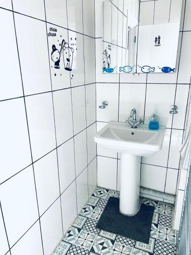 a white bathroom with a sink and a mirror at Jey's Flat in Liverpool