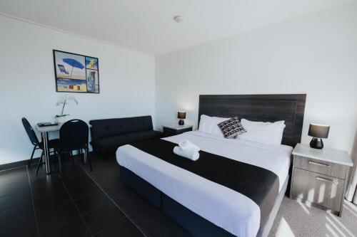 a hotel room with a large bed and a desk at Comfort Inn Traralgon in Traralgon