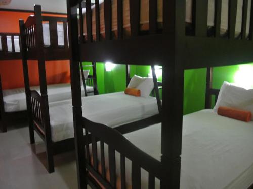two bunk beds in a room with green walls at Silla Patong Hostel in Patong Beach