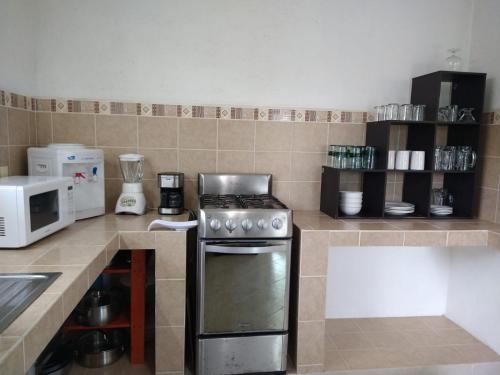 a kitchen with a stove and a microwave at Casa con alberca privada y agradable jardín in Oaxtepec