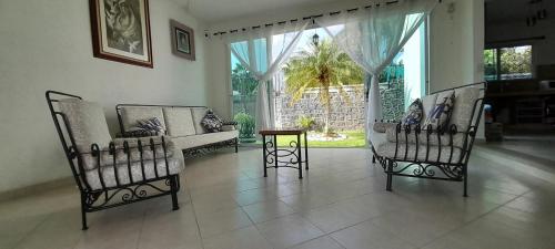 a living room with two chairs and a table at Casa con alberca privada y agradable jardín in Oaxtepec