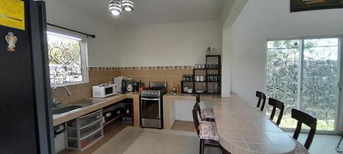a kitchen with a table and chairs and a counter top at Casa con alberca privada y agradable jardín in Oaxtepec