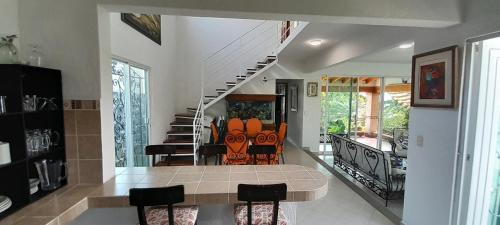 a living room with a table and chairs and a staircase at Casa con alberca privada y agradable jardín in Oaxtepec