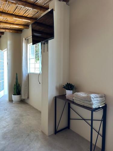 Habitación con mesa y TV en la pared. en GLAMPING TONELES Y VIÑEDOS en San Juan Bautista
