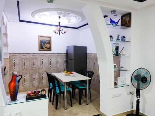 une salle à manger avec une table, des chaises et un ventilateur de plafond dans l'établissement Mira Appartement -Lovely, Tidy & Close to beaches and city center, à Al Hoceïma