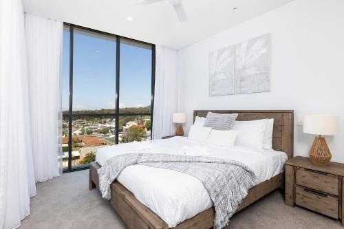 a bedroom with a bed and a large window at Solaris 505 in Forster
