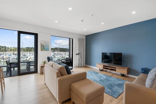 uma sala de estar com um sofá e uma televisão em Bay of Islands Apartment with Marina Views em Opua