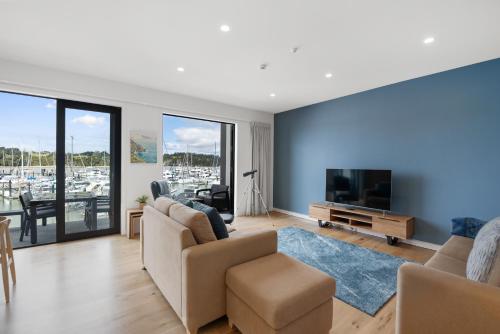a living room with a couch and a television at Bay of Islands Apartment with Marina Views in Opua