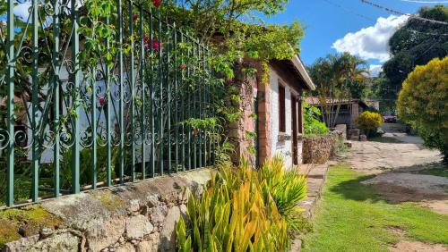 a fence in front of a house with plants at Casa de Silvana - Igatu in Andaraí