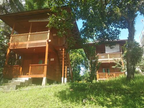 una casa en el árbol con terraza y escalera en Bunaken Sea Garden Resort, en Bunaken