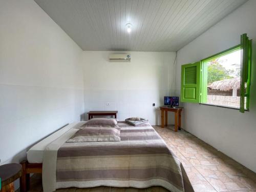 um quarto com uma cama grande e uma janela em Pousada dunas em Luís Correia