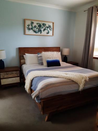 a bedroom with a large bed with a blanket at The Lakes Apartments in Lakes Entrance