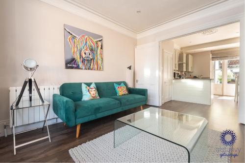 a living room with a green couch and a glass table at The Old Office in Royal Tunbridge Wells