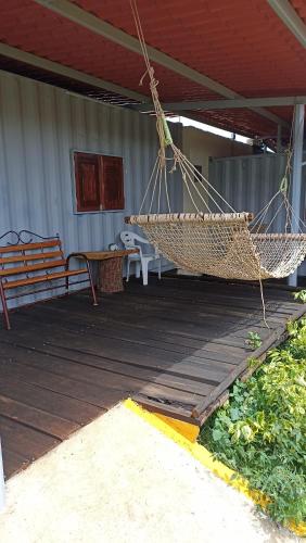 a porch with a hammock on a wooden deck at Contenedor de barco glamping 