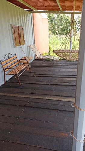 a porch with a bench and hammocks on it at Contenedor de barco glamping 