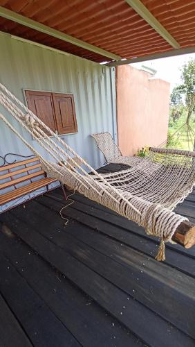 a hammock on the porch of a house at Contenedor de barco glamping 