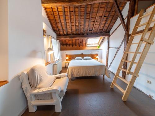 een slaapkamer met een bed en een ladder en een bed en stoel bij Stunning home for 5 adults with indoor pool in Esneux