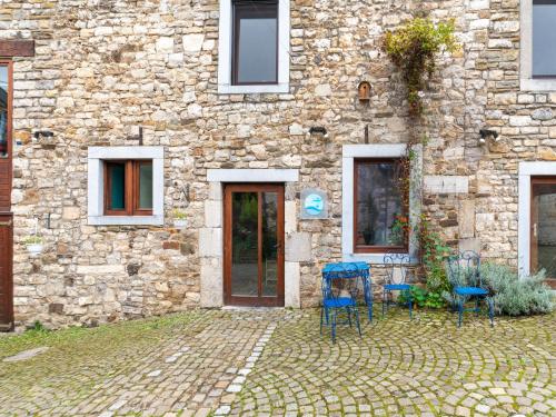 a stone building with two blue chairs in front of it at Riverside Loft in Esneux in Esneux