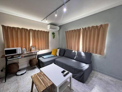 a living room with a couch and a table at Airstar Hakata House in Fukuoka