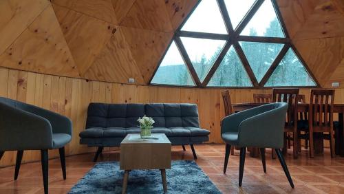 a living room with blue couches and a table at Domos Maran in Villarrica