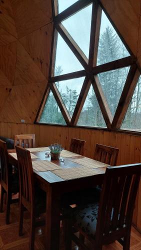 a large wooden table in a room with windows at Domos Maran in Villarrica