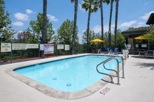 a swimming pool at a resort with palm trees at Hampton Inn & Suites Agoura Hills in Agoura Hills