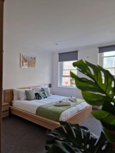 a bedroom with a bed with a plant in the foreground at Farringdon in London
