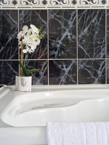 a white bath tub with a vase of flowers in a bathroom at Farringdon in London