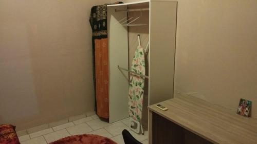 eine Küche mit einem Kühlschrank und einem Duschvorhang in der Unterkunft chambre climatisée avec bureau in Saint-Joseph