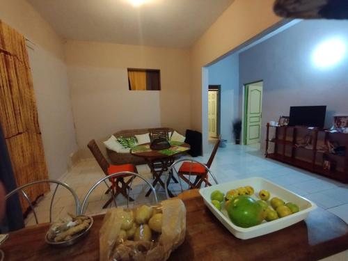 ein Wohnzimmer mit einem Tisch und einer Obstschale in der Unterkunft chambre climatisée avec bureau in Saint-Joseph