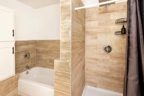 a bathroom with a shower with a white tub at A Place to Escape A Room Within A House in Birmingham