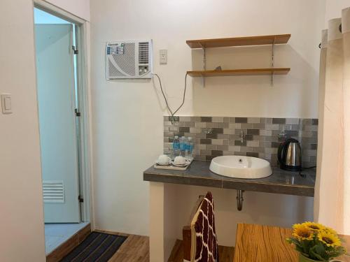 La salle de bains est pourvue d'un lavabo et d'un comptoir. dans l'établissement JCV Rooms, à Surigao