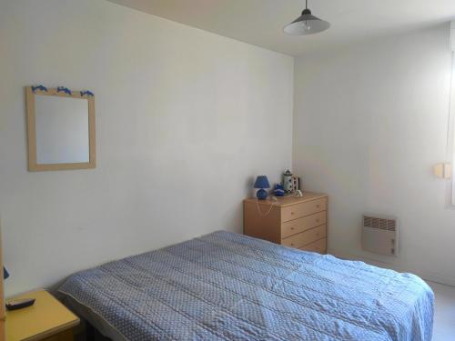 1 dormitorio con cama, tocador y espejo en Appartement Arzon, 2 pièces, 4 personnes - FR-1-639-32, en Arzon