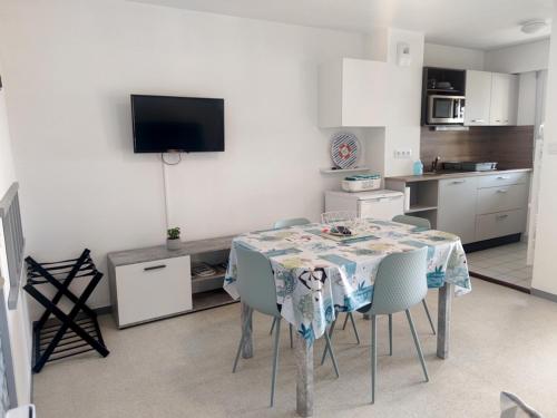 une cuisine avec une table et des chaises dans une pièce dans l'établissement Charmant apt famille avec balcon au Port du Crouesty, parking inclus - FR-1-639-55, à Arzon