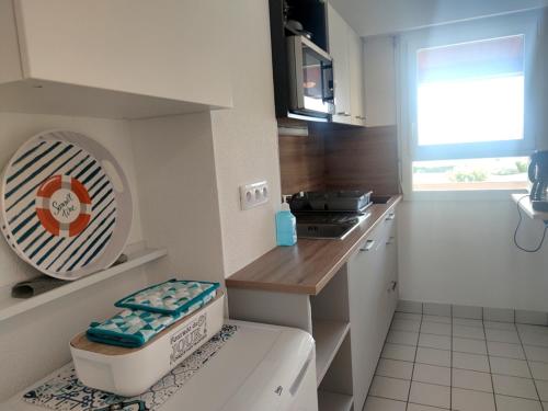 a small kitchen with a counter and a sink at Charmant apt famille avec balcon au Port du Crouesty, parking inclus - FR-1-639-55 in Arzon