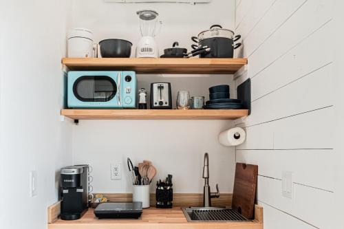 a kitchen with wooden shelves and a microwave at Vanderbilt Beach Studio in Naples
