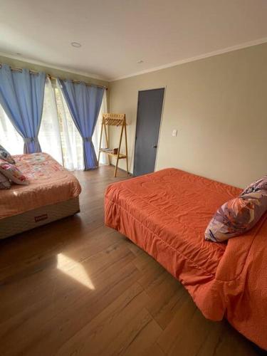 a bedroom with two beds and a wooden floor at Casa Montegrande in Monte Grande