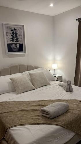 um quarto com uma grande cama branca com almofadas em Apartamento en el Corazón de Boquete em Boquete
