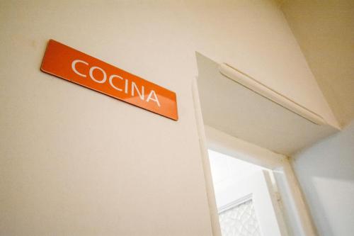 an orange sign on a wall next to a door at Anden Aristides in Mendoza
