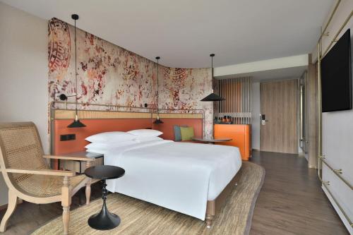 a bedroom with a large white bed and a desk at The Artiste Kochi, a Tribute Portfolio Hotel in Cochin