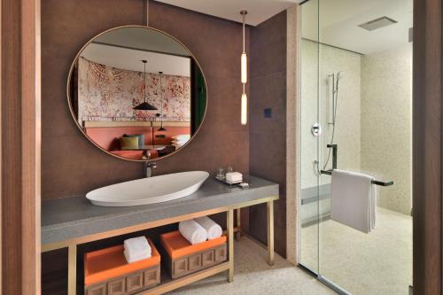 a bathroom with a sink and a mirror at The Artiste Kochi, a Tribute Portfolio Hotel in Cochin
