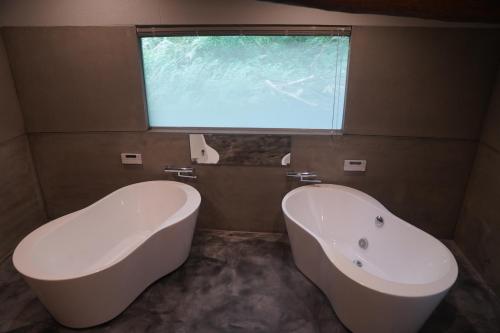 a bathroom with a tub and a sink and a window at LOOP-shiso 宍粟市BBQとサウナでととのう天空回廊にたたずむ貸別荘 in Shiso