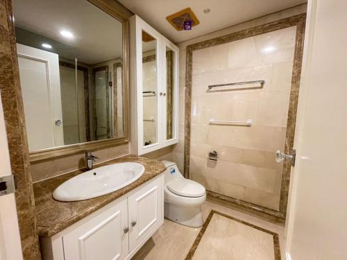 uma casa de banho com um lavatório, um WC e um espelho. em Elegance penthouse em Surabaya