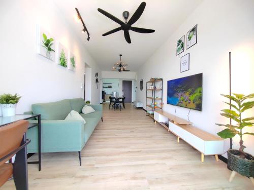 sala de estar con sofá azul y ventilador de techo en Monstera Meritus Homestay - Penang Butterworth Prai 1-8PAX en Perai
