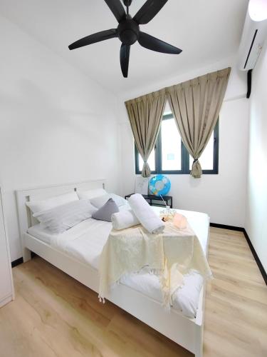a bedroom with a white bed with a ceiling fan at Monstera Meritus Homestay - Penang Butterworth Prai 1-8PAX in Perai