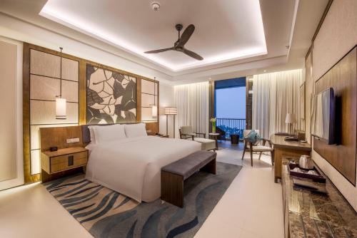 a hotel room with a bed and a television at Hilton Wenchang in Wenchang