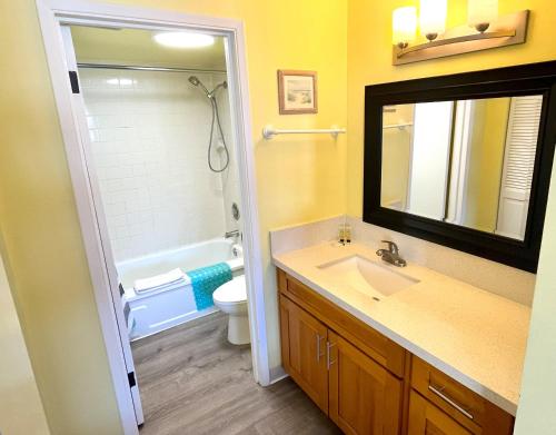 ein Badezimmer mit einem Waschbecken, einem WC und einem Spiegel in der Unterkunft Royal Kuhio 1602 - Spacious Studio with Stunning Mountain Views in the Heart of Waikiki! in Honolulu